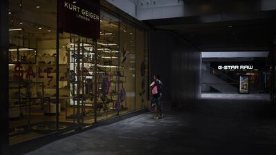 A woman looks at a showcase as she walks past a shoe store in Beijing. Growth in Chinese exports and imports outstripped expectations in June, official data showed, but analysts warned the pick up could be temporary. Wang Zhao / AFP