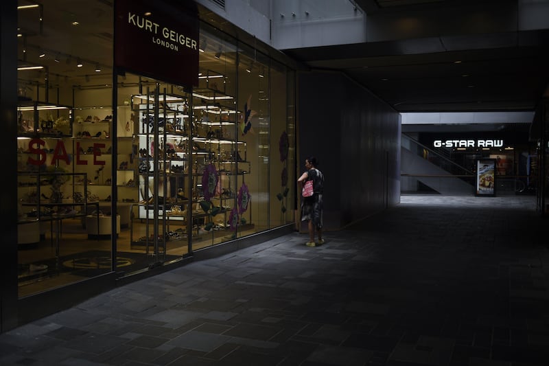 A woman looks at a showcase as she walks past a shoe store in Beijing. Growth in Chinese exports and imports outstripped expectations in June, official data showed, but analysts warned the pick up could be temporary. Wang Zhao / AFP