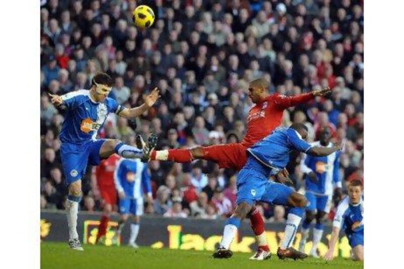David Ngog heads the ball under pressure from the Wigan defenders.