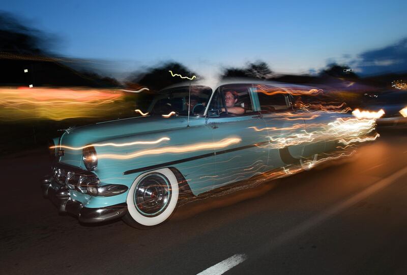 A dream cruiser rolls by in streaks of headlights and tail lights at dusk on Woodward Avenue in Royal Oak, Michigan.  AP
