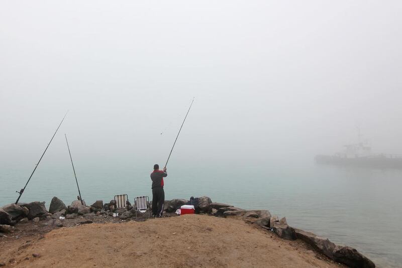 A man fishes off the coast of Abu Dhabi despite heavy fog on January 9, 2011. Rich-Joseph Facun / The National