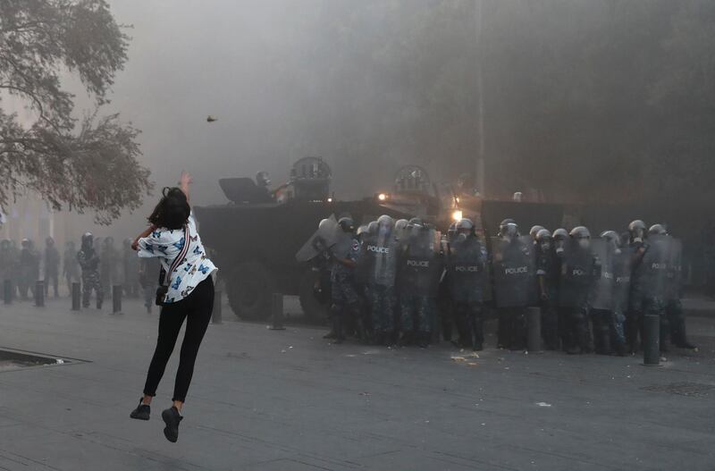 An anti-government protester throws a stone towards riot police during a protest near Parliament Square. AP