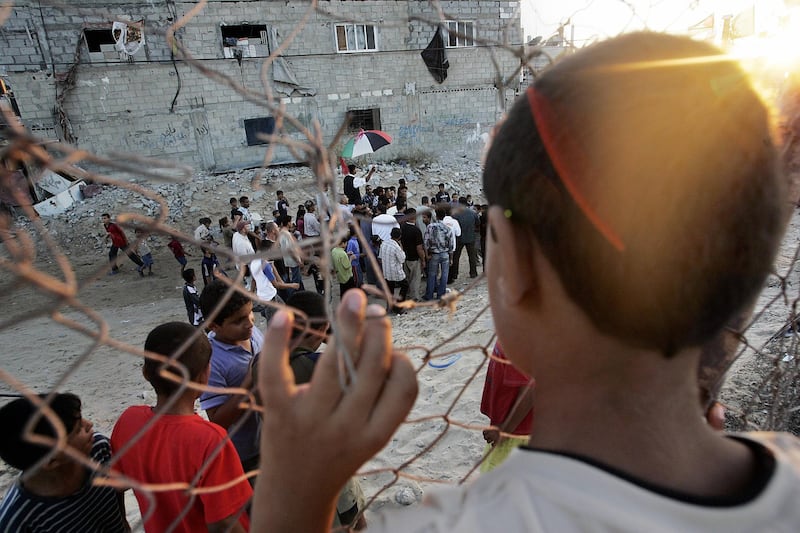 A Palestinian boy watches as 17-year-old Ibrahim Abu Sahluheen, who is preparing to wed tonight, is paraded on the shoulders of family and friends at the streets of his neighborhood in the southern Gaza Strip town of Khan Yunes 09 September 2005. Some 7,200 Plaestinian national security forces and police are deployed across the southern Gaza Strip from Khan Yunis to the border town of Rafah, as the Israeli troops pack up their bags waiting for the moment of handover.   AFP PHOTO/Roberto SCHMIDT / AFP PHOTO / ROBERTO SCHMIDT