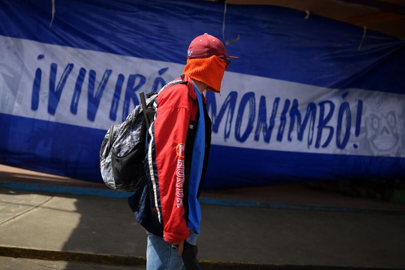 TOPSHOT - A paramilitary is seen in a street of Monimbo neighborhood next to a flag reading "You will live Monimbo!" in Masaya, Nicaragua, on July 18, 2018, following clashes with anti-government demonstrators. The head of the Inter-American Commission on Human Rights has described as "alarming" the ongoing violence in Nicaragua, where months of clashes between protesters and the forces of President Daniel Ortega have claimed almost 300 lives. / AFP / MARVIN RECINOS
