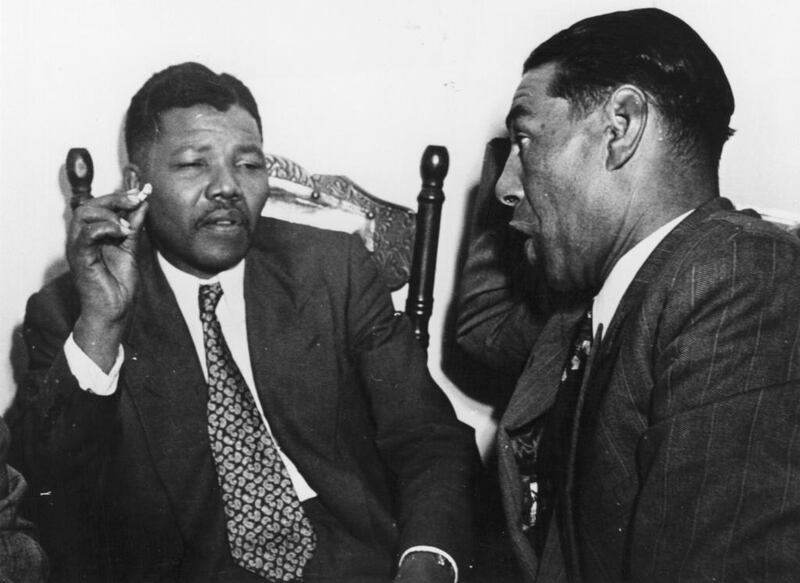 Circa 1964: Nelson Mandela, President of the African National Congress, left, in discussion with C Andrews, a Cape Town teacher. Three Lions / Getty Images