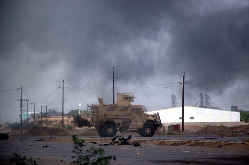 Yemeni government forces patrol as smoke billows from an alleged Houthi position during battles between Yemeni government forces and Houthi rebels in the port city of Hodeidah. EPA