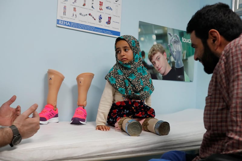 Maya with her father Mohammed at the prosthetic centre in Istanbul. Reuters