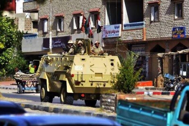 An Egyptian military armoured personnel carrier patrols a street in the Sheikh Zowied town near Rafah, in the northern Sinai on May 20, 2013. Egypt sent police reinforcements to the Sinai after an attack on a police camp in the wake of the kidnapping of seven security personnel in the lawless peninsula, officials said. AFP PHOTO/MOHAMED EL-SHAHED *** Local Caption *** 158658-01-08.jpg