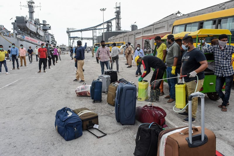 Indian nationals previously stranded in Iran wait on the docks, while their belongings are cleaned, after arriving with the Indian Naval Ship (INS) Shardul at Porbandar as part of a repatriation effort due to the COVID-19 coronavirus. AFP