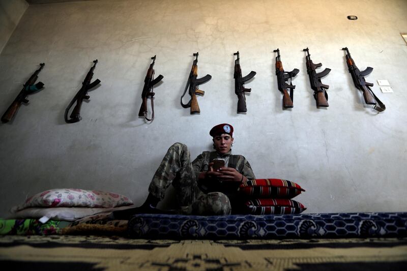 A fighter from Free Syrian Army (Al-Hamza Brigade) chats on his mobile in Hazwan town in Aleppo, Syria. Khalil Ashawi / Reuters