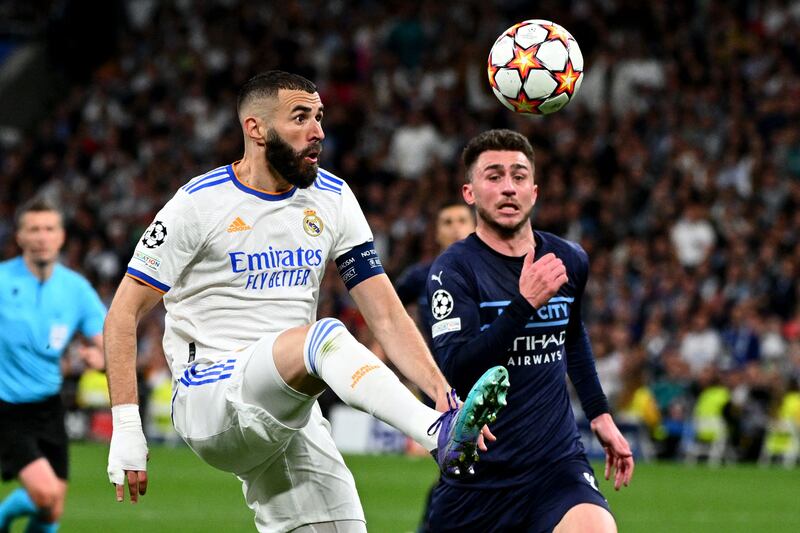 Real Madrid's French forward Karim Benzema vies for the ball with Manchester City's Spanish defender Aymeric Laporte during the Champions League semi-final second leg on May 4, 2022. AFP