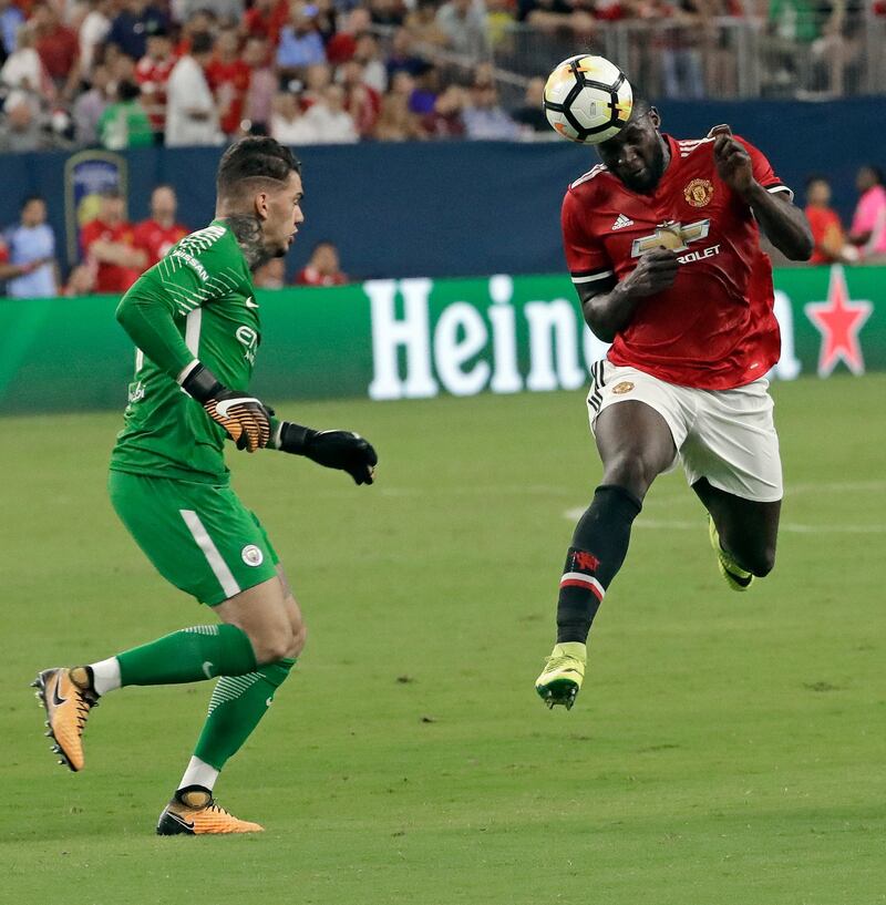 Manchester United's Romelu Lukaku, right, heads the ball past Manchester City goalkeeper Ederson. David J. Phillip / AP Photo