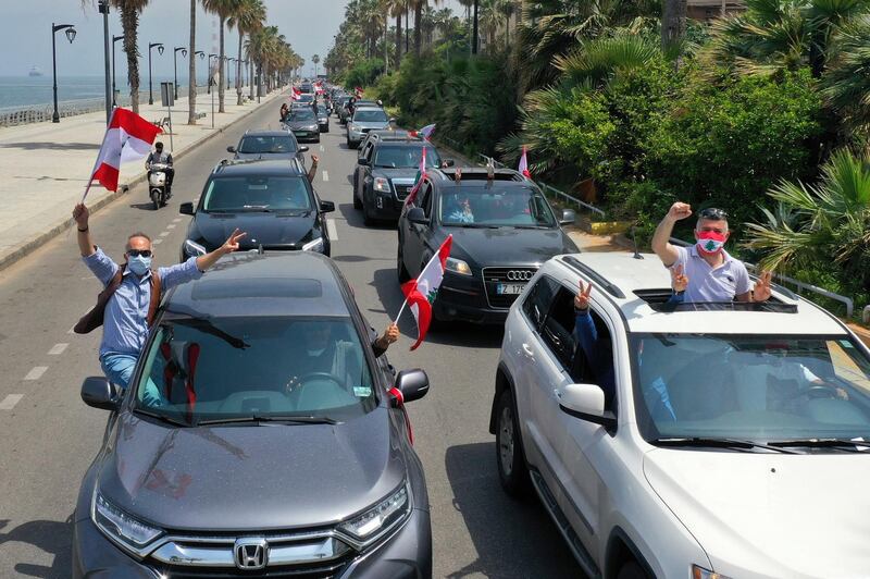Anti-government protesters waving Lebanese flags on April 21 as they drive through the streets to protest the economic situation at Corniche Al Manara in Beirut, Lebanon,.  EPA