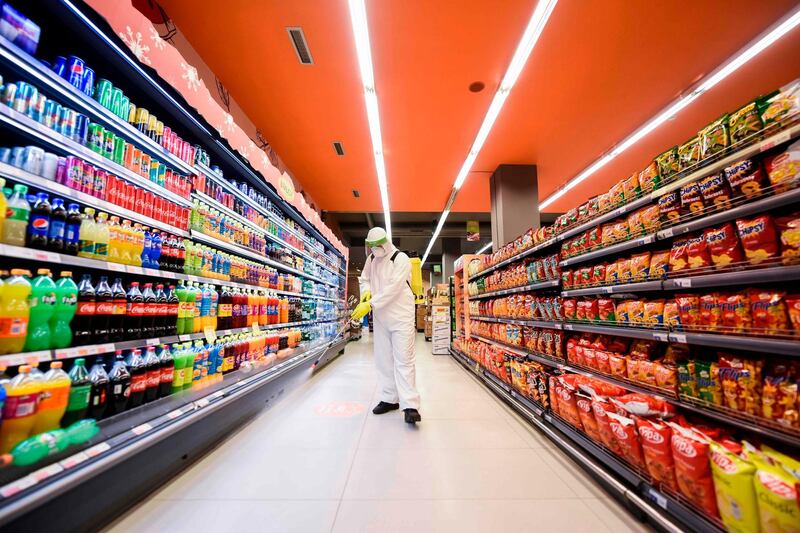 A worker disinfects the floor of a supermarket in Pristina, Kosovo. AFP