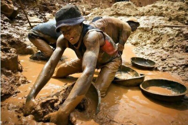 A gold miner scoops mud while digging an open pit at the Chudja mine in the Kilomoto concession near the village of Kobu, 100 km (62 miles) from Bunia in north-eastern Congo, February 23, 2009. Civil conflict in Congo has been driven for more than a decade by the violent struggle for control over the country's vast natural resources, including gold, diamonds and timber, most of which is exploited using hard manual labour. REUTERS/Finbarr O'Reilly (DEMOCRATIC REPUBLIC OF CONGO)