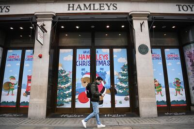epa08904638 A masked man passes a closed Hamleys Toy Shop in an unusually quiet Regents Street in London, Britain, 26 December 2020. Boxing Day is traditionally a very busy time for retailers when they expect large footfall from shoppers due to discounts and sales. Harsher Covid restrictions now apply to millions more people, as rule changes come into force across the UK. Some 24 million people in England, more than 40 per cent of the population have gone into tier four, England's highest Covid level - which includes a 'stay at home' order. The toughest measures mean the closure of all non-essential shops, and businesses such as hairdressers, swimming pools and gyms.  EPA/NEIL HALL