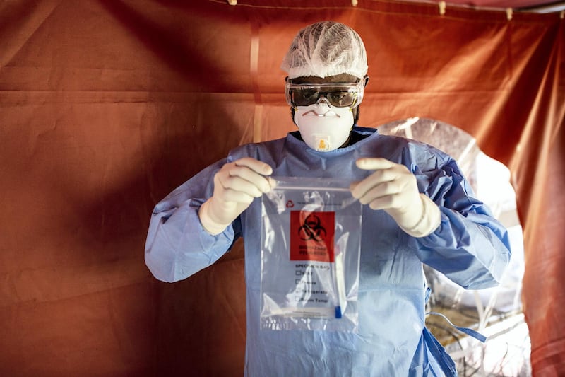 A doctor dressed in personal protective equipment (PPE) sealed a bag containing an oropharyngeal swab samples for Covid-19 testing at the Aga Khan University Hospital in Nairobi, Kenya, on Friday, April 24, 2020. The East African country enforced a curfew as part of measures to reduce the risk of contagion amid fears that Covid-19 patients will overrun its health system. Photographer: Patrick Meinhardt/Bloomberg via Getty Images