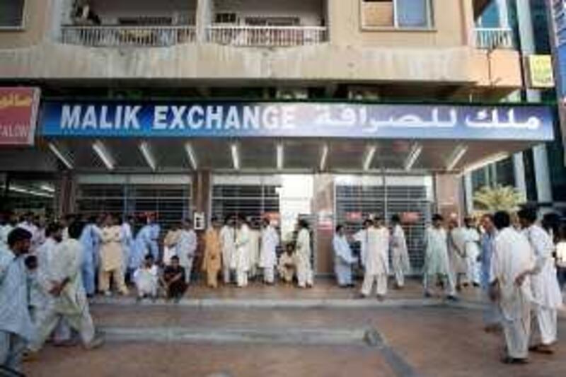 Abu Dhabi-November 28, 2008: Men line up at this money exchange on Hamdan Street in Abu Dhabi, November 28, 2008. (Jeff Topping/The National) *** Local Caption ***  JT001-1128-Money Exchange Stock 7F8Q7675.jpgJT001-1128-Money Exchange Stock 7F8Q7675.jpg