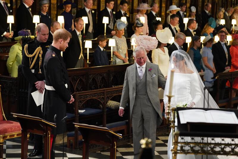 Prince Harry looks at his bride, Meghan Markle, as she arrives accompanied by Prince Charles during their wedding in St George's Chapel at Windsor Castle in Windsor. Jonathan Brady / Getty Images