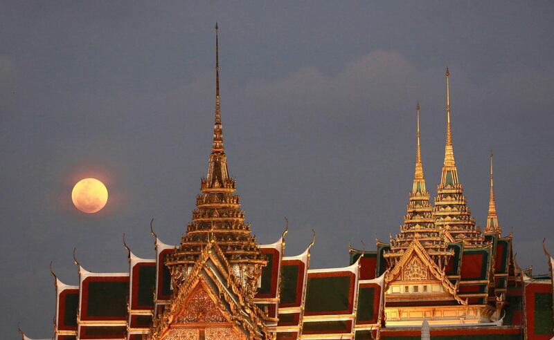 A full moon rises behind the Grand Palace in Bangkok, Thailand , Wednesday, Jan. 31, 2018. The moon is putting on a rare cosmic show. It's the first time in 35 years a blue moon has synced up with a supermoon and a total lunar eclipse. (AP Photo/Sakchai Lalit)