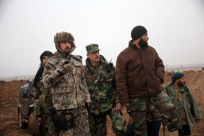 Syrian pro-government fighters, led by Colonel Suheil al-Hassan (L), known as the 'Nimr', Arabic for Tiger, hold a position near the Syrian village of Al-Najjarah, east of the northern Syrian city of Aleppo on January 7, 2016 as regime forces have recaptured several areas in the north of the country from Islamist jihadists. Eastern parts of Aleppo province are held by the Islamic State jihadist group, and the west is held by opposition groups ranging from US-backed rebels to Al-Nusra.  AFP PHOTO / GEORGE OURFALIAN (Photo by GEORGE OURFALIAN / AFP)