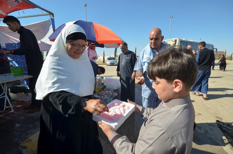 A boy offers sweets to Hajj pilgrims leaving for Makkah, in Maan, Jordan. Reuters