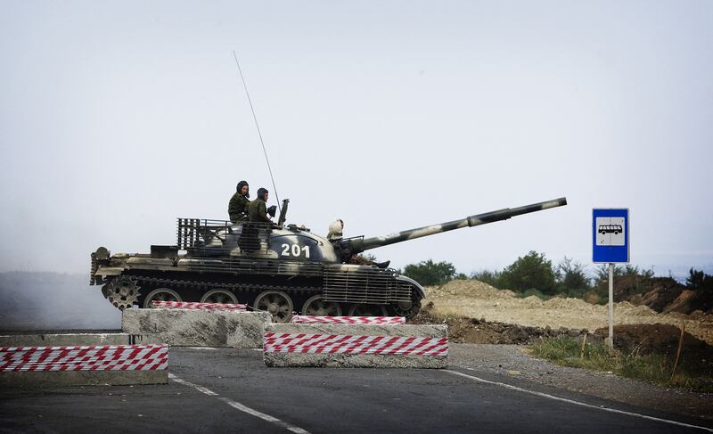 A Russian T62 tank crosses the empty highway linking Tbilisi and western Georgia on August 21, 2008 at a checkpoint manned by the Russian forces. AFP