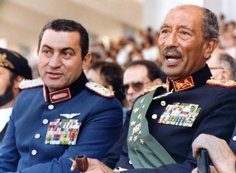 Egyptian vice President, Gen. Hosni Mubarak (L) and late President Anwar Sadat (R), both dressed in military honour uniforms, attend a military parade, 06 October 1981, in Cairo, commemorating Victory Day. Moments after, a group of military Islamist fundamentalists with allegiance to the Al-Jihad group killed Sadat in a shooting spree. Following Sadat's assassination Mubarak was sworn in as Egypt’s fourth president, a position of power he has since retained, being re-elected five times. AFP PHOTO/- (Photo by AFP PHOTO / AFP)