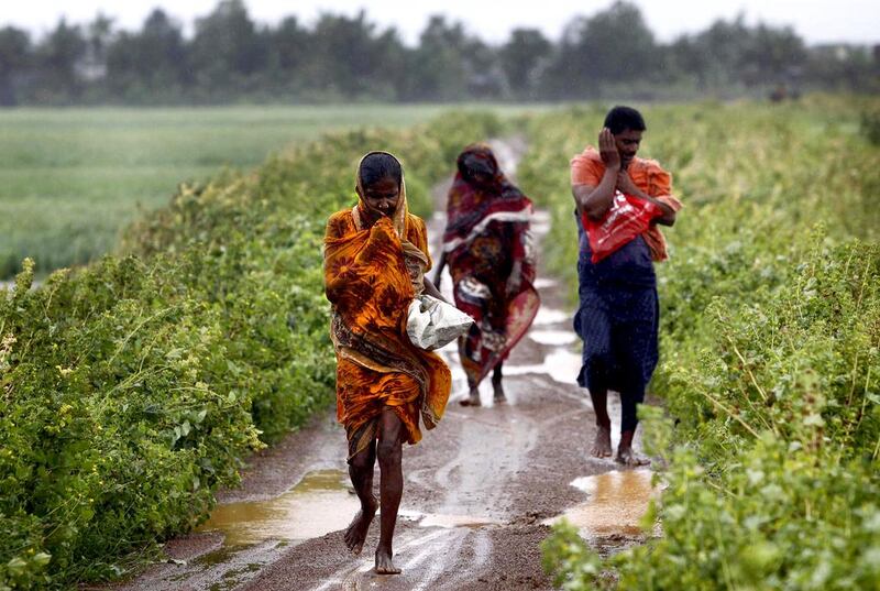 Indian villagers brave strong winds and rain to reach a cyclone centre in Podampeta, eastern India. Biswaranjan Rout / AP 