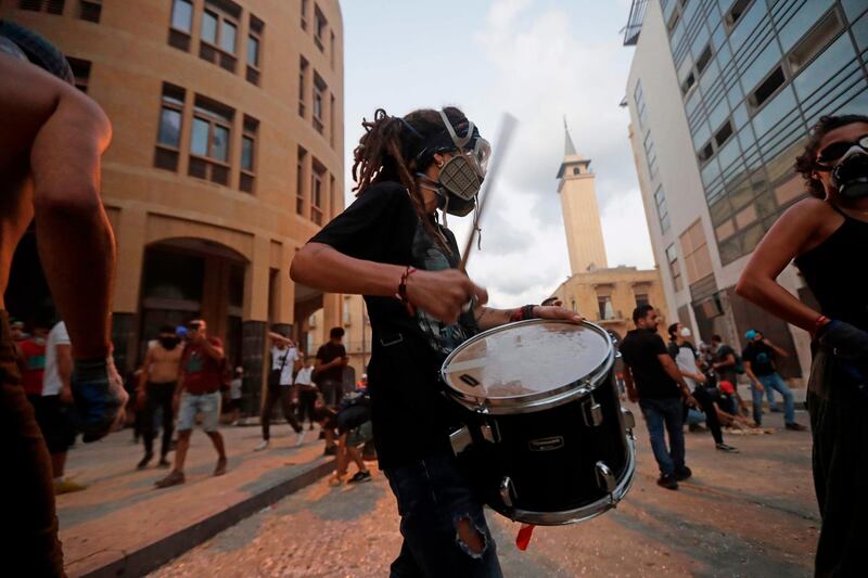 A Lebanese protester beats a drum amid clashes with security forces near an access street to the parliament in central Beirut.  AFP