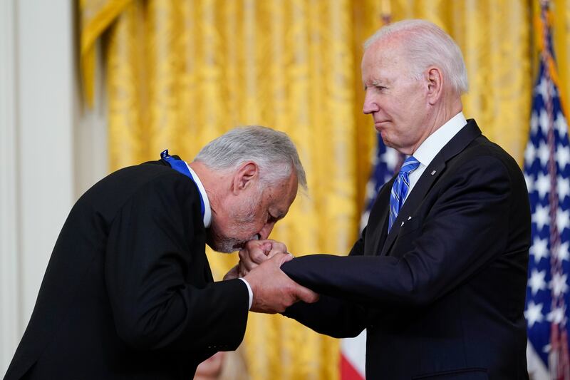 Father Karloutsos kisses Mr Biden's hand at the ceremony. AP