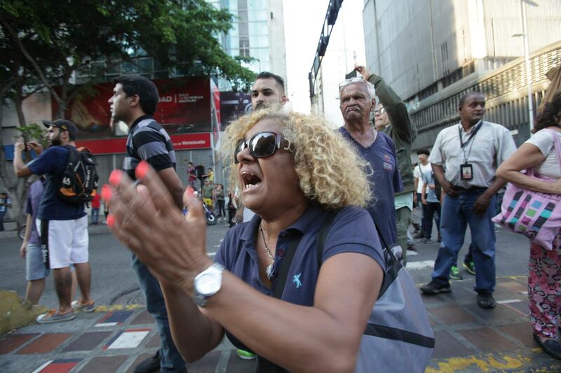 People shout slogans against Venezuela's President Nicolas Maduro during a blackout in Caracas, Venezuela. AP Photo