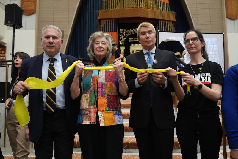 From left, Col Kemp, Lipman, London and businesswoman Nivi Feldman hold a yellow ribbon to show support for the hostages in Gaza. PA