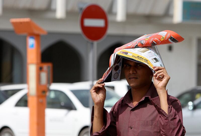 
DUBAI, UNITED ARAB EMIRATES, June 17: One of the person covering himself with magazine to avoid heat stroke at Karama in Dubai. (Pawan Singh / The National) For News.
