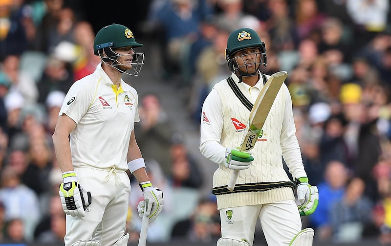 epa06362958 Australian captain Steve Smith looks on as Usman Khawaja raises his bat after scoring a half century on Day 1 of the Second Test match between Australia and England at the Adelaide Oval in Adelaide, Australia, 02 December 2017. (IMAGES TO BE USED FOR NEWS REPORTING PURPOSES ONLY, NO COMMERCIAL USE WHATSOEVER, NO USE IN BOOKS WITHOUT PRIOR WRITTEN CONSENT FROM AAP)  EPA/DAVE HUNT AUSTRALIA AND NEW ZEALAND OUT  EDITORIAL USE ONLY