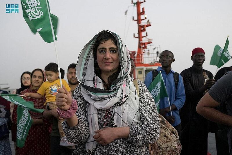 A woman waves a Saudi flag in Jeddah after being evacuated by the kingdom. Reuters