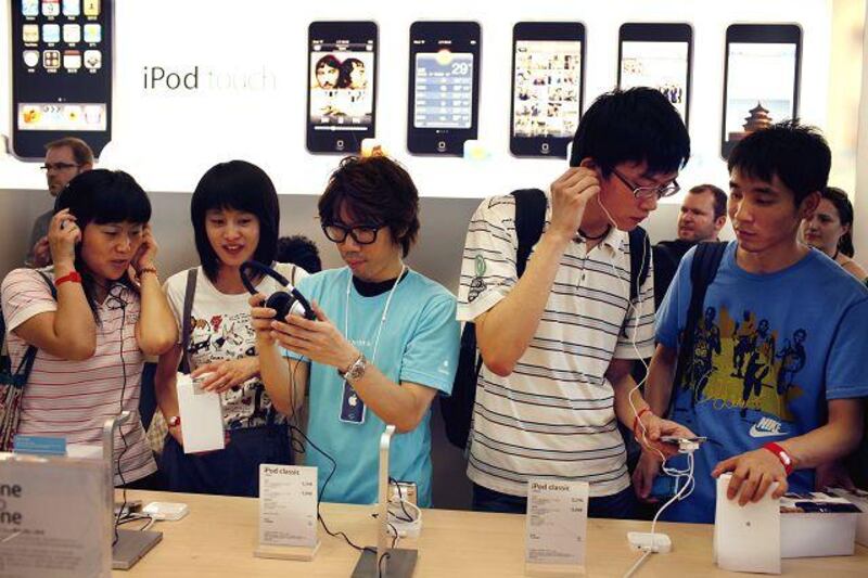 People browse Apple Inc. products at the Apple store in Beijing, China, on Saturday, July 19, 2008. Apple Inc., who is expected to release earnings on July 21, opened its first company-owned retail outlet in China today. Photographer: David Butow/Bloomberg News