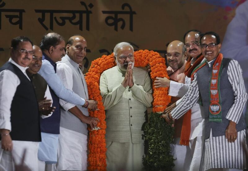 Narendra Modi is garlanded during a reception at the BJP headquarters in New Delhi a day after the party won in key state legislature elections. AP Photo