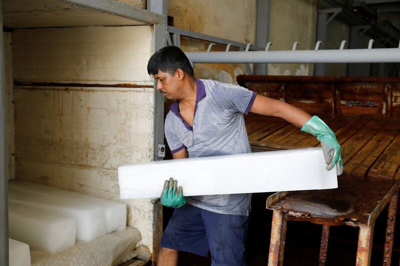 A workman shifting ice blocks during the heatwave in Iraq.