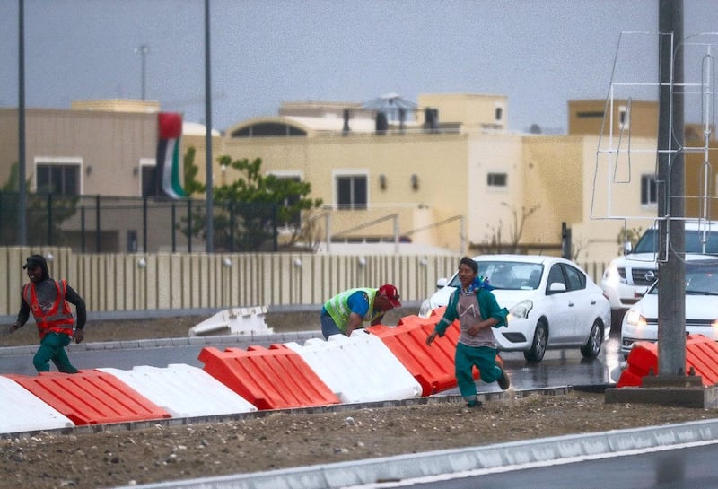 Road workers clear the street from flying debris from the strong winds in Khalifa City, Abu Dhabi. Victor Besa / The National
