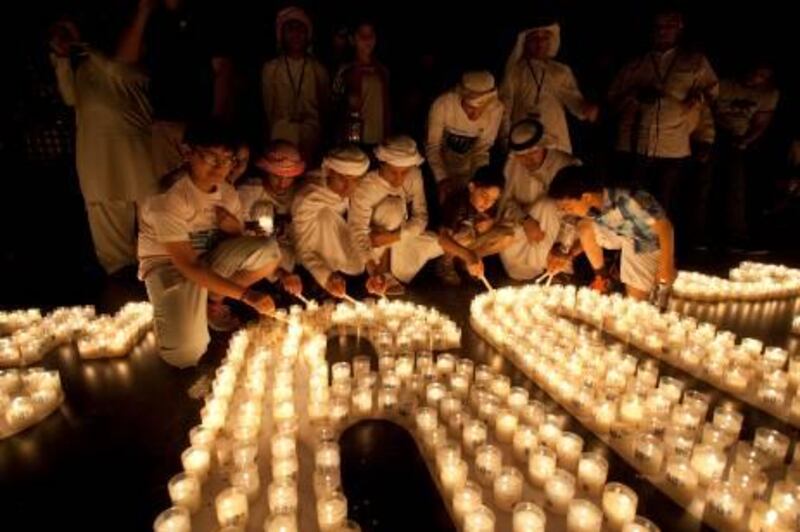 DUBAI, UNITED ARAB EMIRATES - MARCH 31:  Young Emirati boys gather to light candles as the lights at the Burj Khalifa were turned off for 60 minutes in acknowledgement of Earth Hour at the Burj Park in Dubai, on March 31, 2012.  (Randi Sokoloff for The National)  For News
