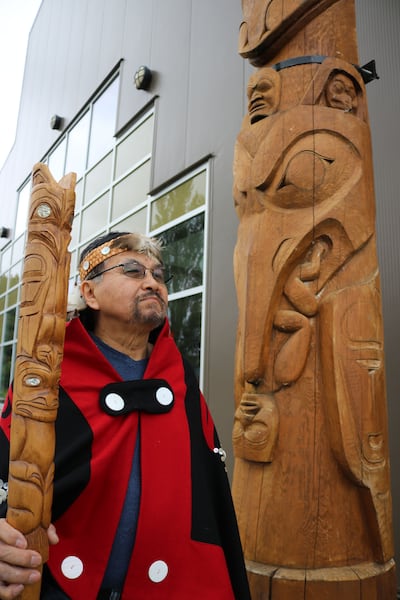 Chief Earl Stephens next to a replica of the Ni'isjoohl memorial pole in the Nisga'a Village of Laxgalts’ap, British Columbia, Canada. Photo: Nisga’a Nation