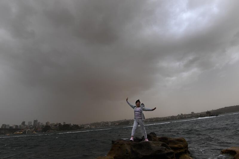 Tourists take photographs as a dust storm descends on Sydney. EPA
