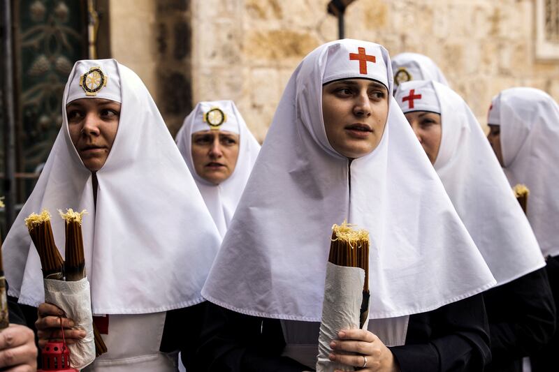Nuns hold candles as Orthodox Christian worshippers attend the Holy Fire ceremony at the Church of the Holy Sepulchre in Jerusalem's Old City, in April 2023. Reuters