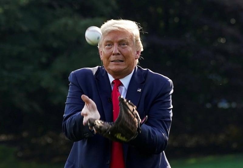 US President Donald Trump catches a ball while hosting youth baseball players at the White House on opening day for Major League Baseball season in Washington on Thursday. Reuters