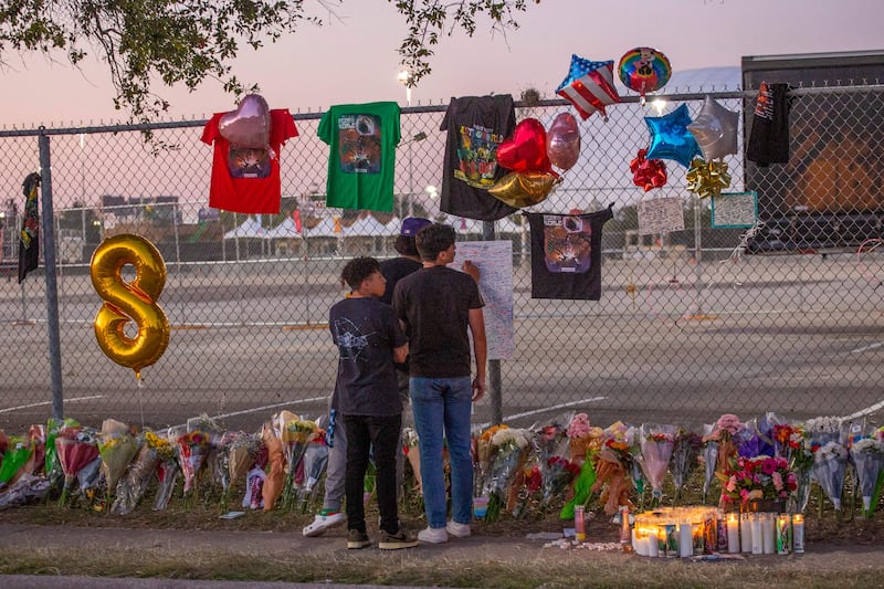 Local high school friends who attended the Travis Scott concert, Isaac Hernandez and Matthias Coronel, both 17, watch Jesus Martinez sign a remembrance board at the memorial. AFP