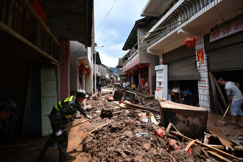 Locals clean up silt and garbage in aftermath of flooding in Yantouzhai, Hunan on Sunday. EPA