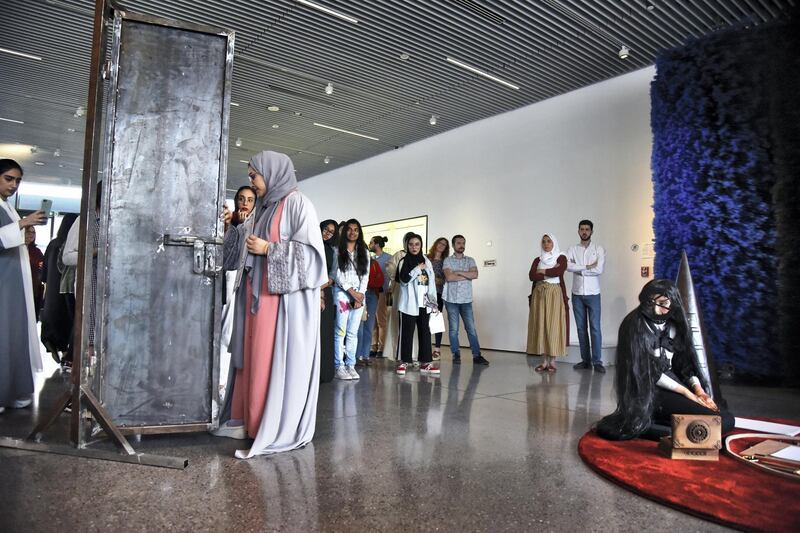 Dubai, UAE, 26 April 2019, Artist Shaikha Fahad Al Ketbi, right, watches as a lady walks through a door during an interactive performance with the crowd at the Jameel Arts Centre. Photos by Shruti Jain