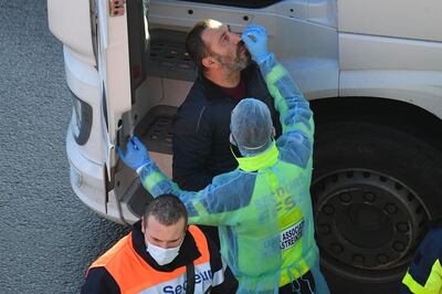 Members of the FFSS (French Federation of Rescue and First Aid) carry out covid-19 tests on lorry drivers close to the entrance to the Port of Dover, in Dover on the south-east coast of England, on December 24, 2020, as the COVID-19 testing of drivers queueing to depart from the ferry terminal to Europe continues. France and Britain reopened cross-Channel travel on Wednesday after a 48-hour ban to curb the spread of a new coronavirus variant but London has warned it could take days for thousands of trucks blocked around the port of Dover to get moving.
 / AFP / JUSTIN TALLIS
