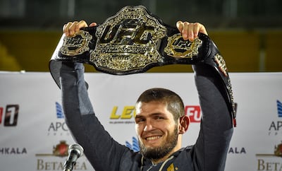 UFC lightweight champion Khabib Nurmagomedov of Russia raises his champions belt upon the arrival in Makhachkala on October 8, 2018. Nurmagomedov defeated Conor McGregor of Ireland in their UFC lightweight championship bout by way of submission during the UFC 229 event inside T-Mobile Arena on October 6, 2018 in Las Vegas, Nevada. / AFP / Vasily MAXIMOV 
